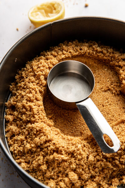 molding graham cracker crumbs in a springform pan