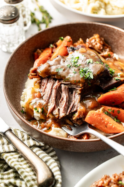 short ribs and carrots on top of mashed potatoes
