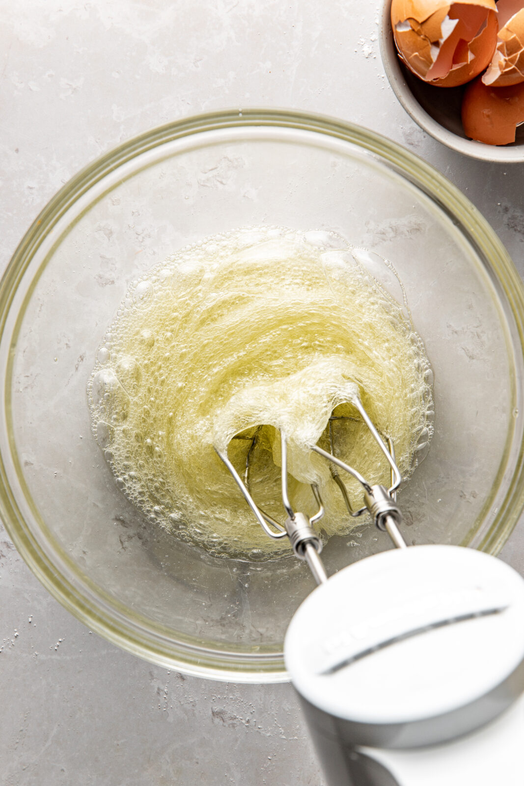 egg whites being whipped in a mixing bowl