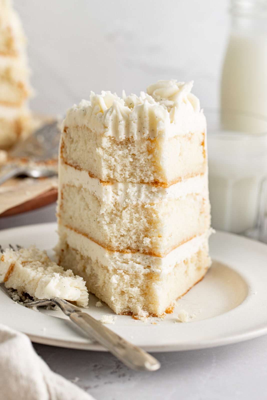white cake on a plate with bit taken out