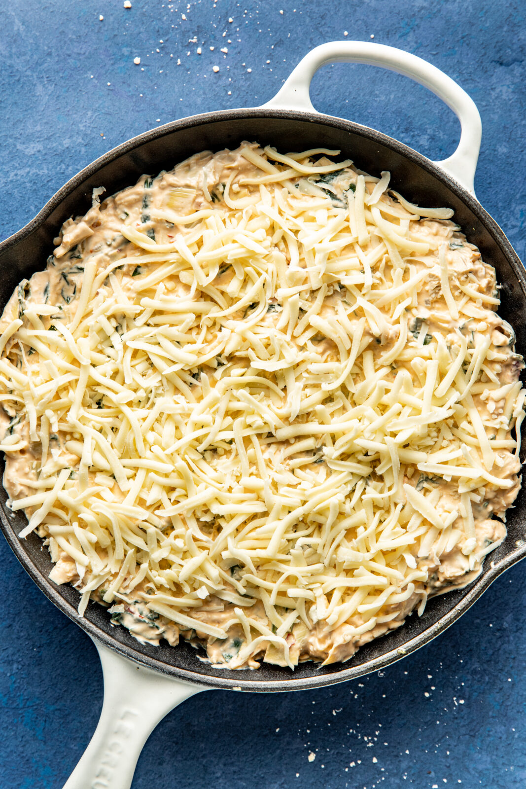 collard green dip in a skillet with added cheese