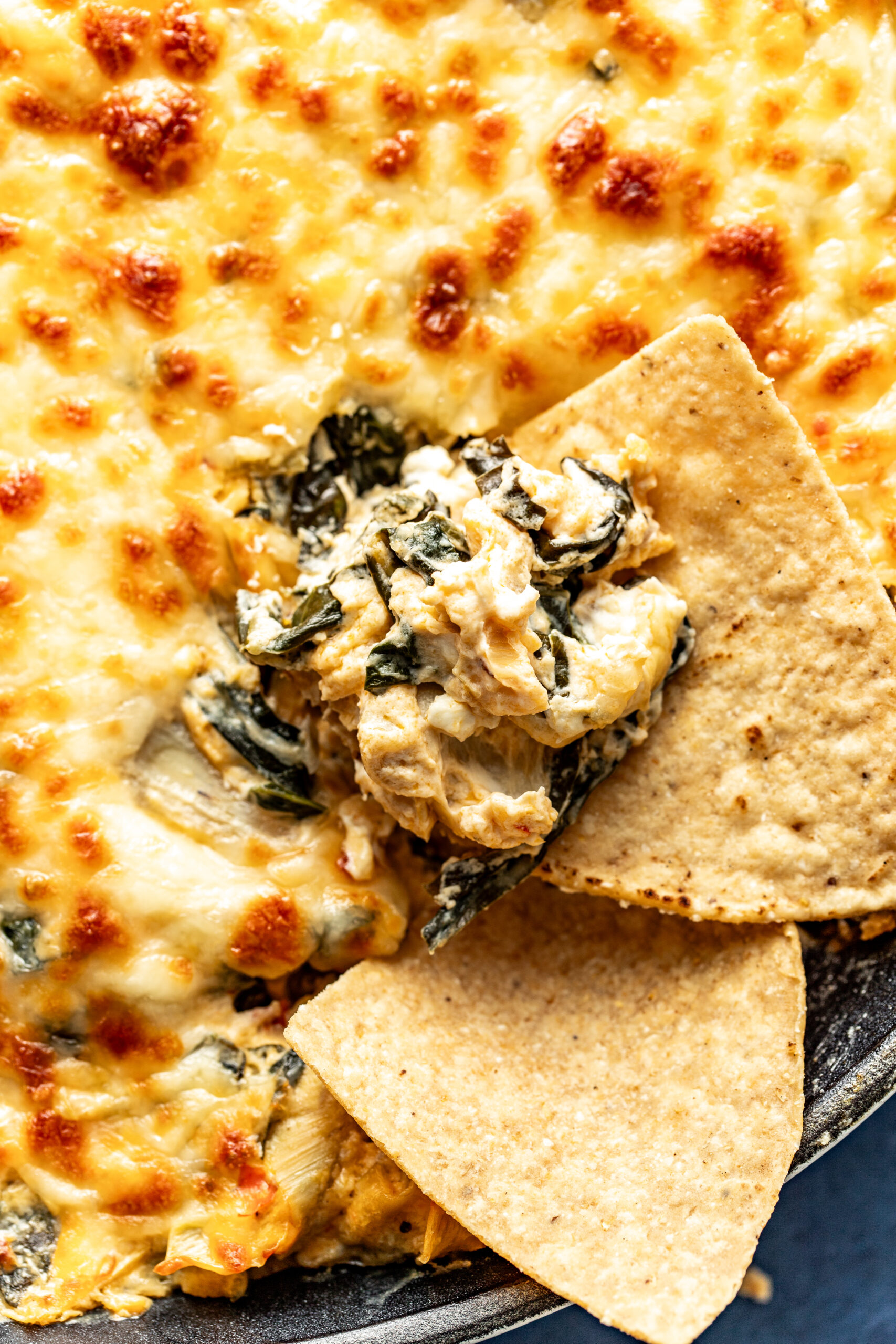 dipping a tortilla chip in collard green dip