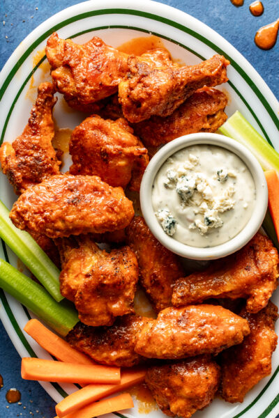 buffalo wings on a platter with veggies