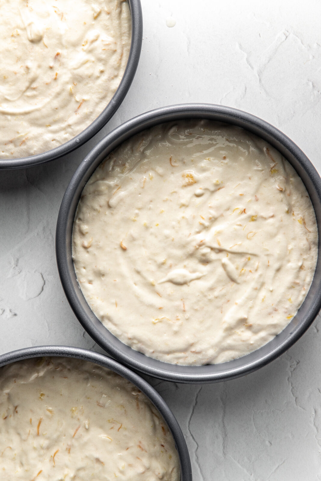 pineapple coconut cake batter added to 3 cake pans 