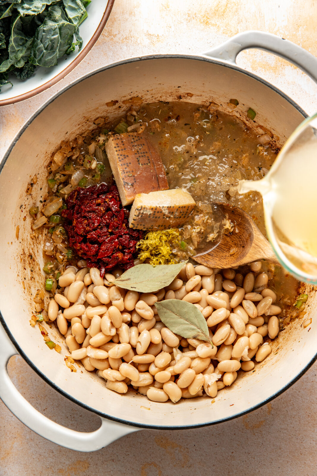 beans, sun-dried tomatoes, bay leaves, and parm added to the soup