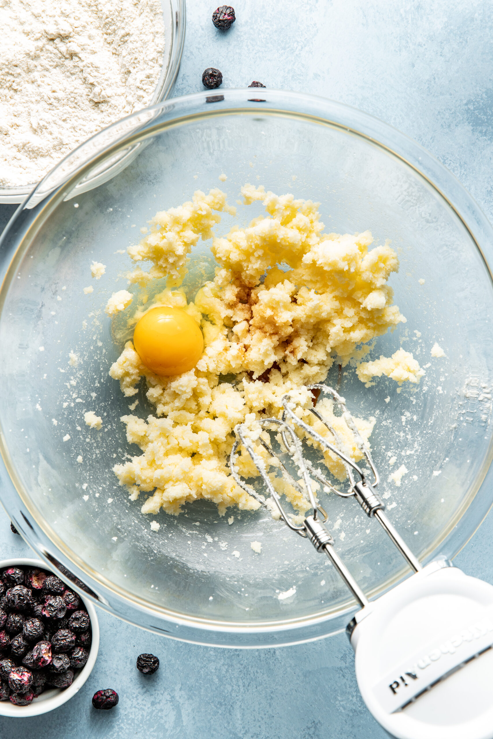 sugar and butter mixed with added egg in a mixing bowl