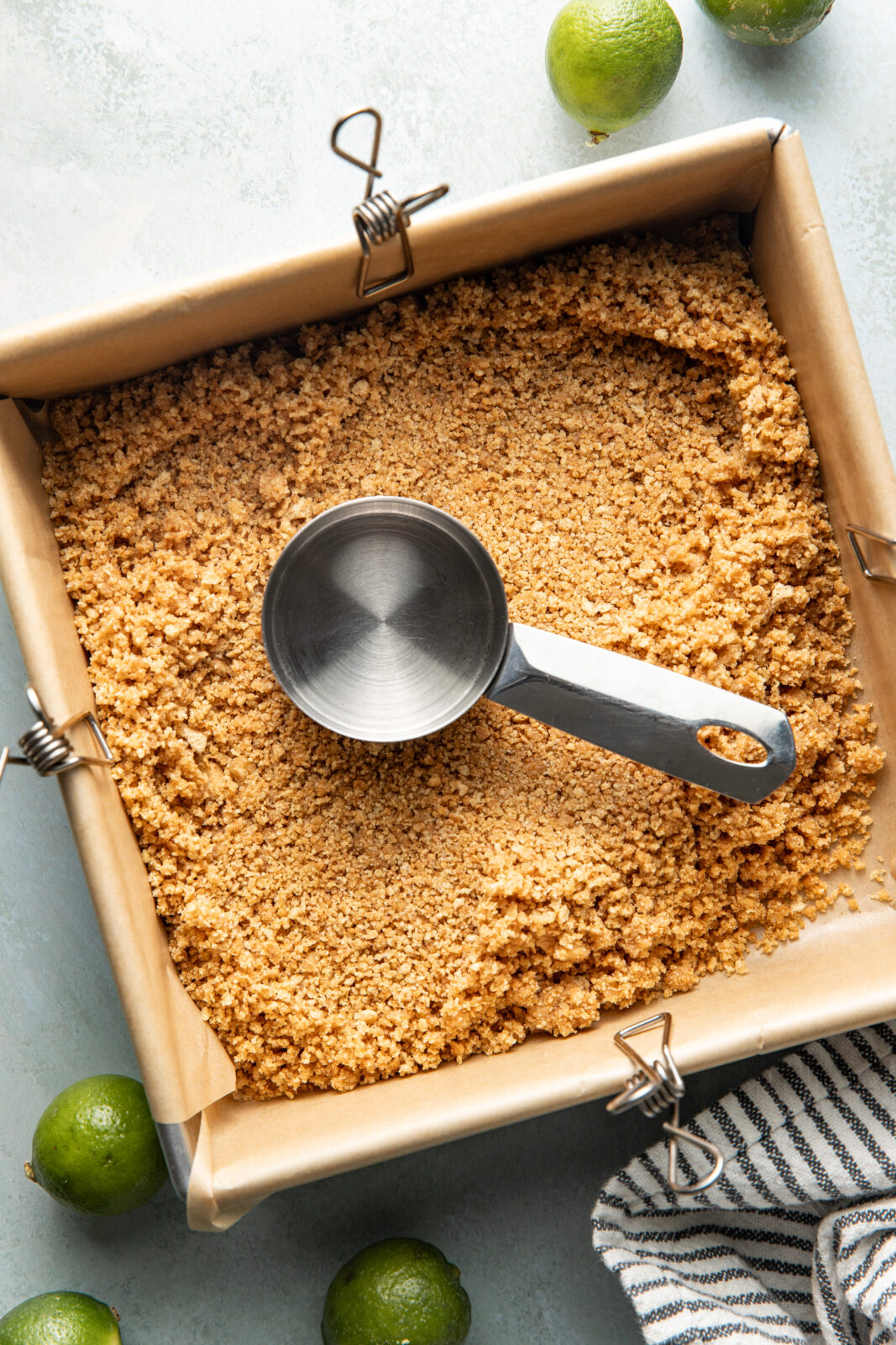 packing the graham cracker crust in 8x8 pan