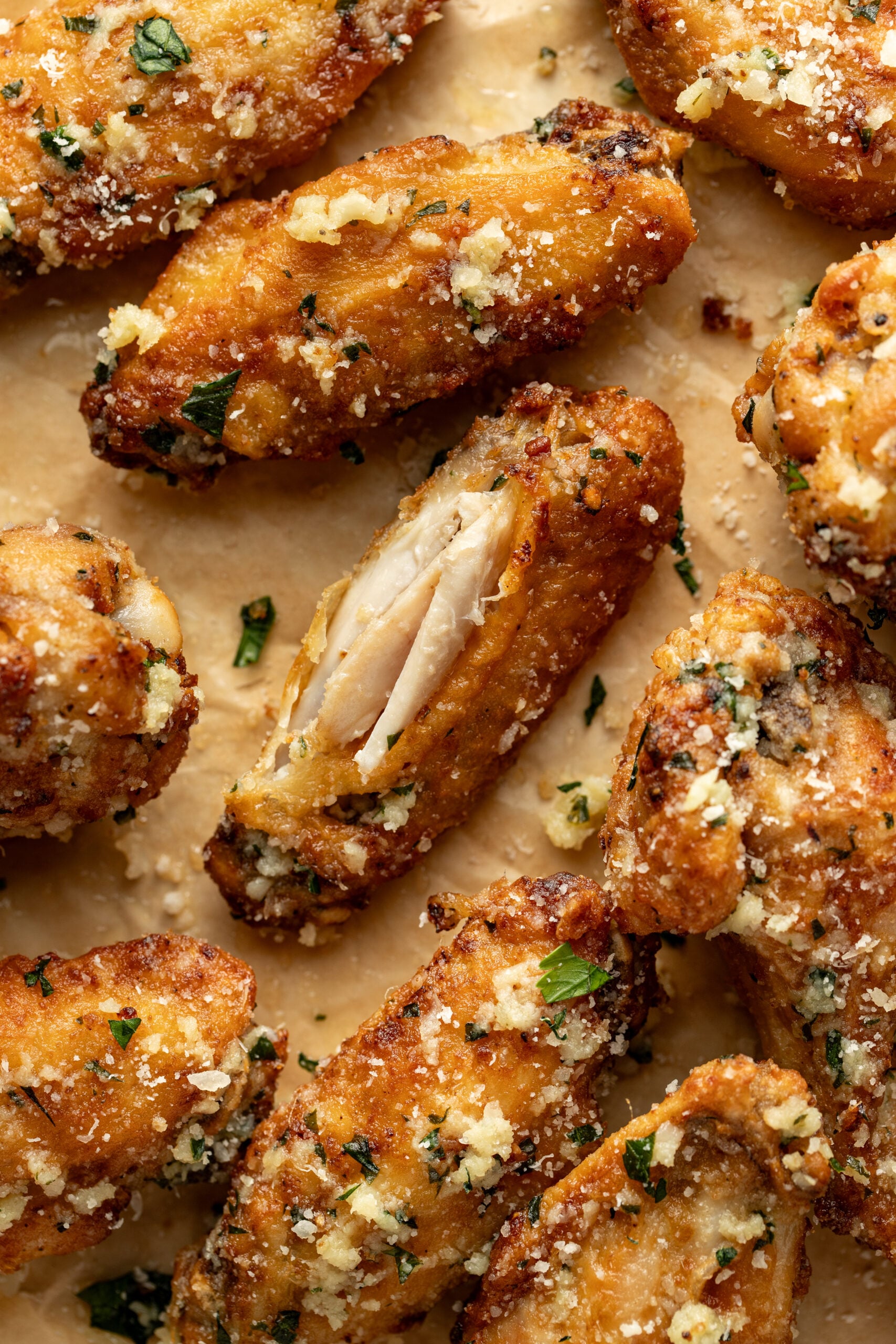 garlic parmesan wings on a platter with one eaten